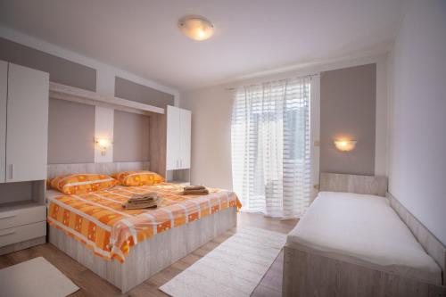 a bedroom with two beds and a large window at Apartments Marija - good location in Supetarska Draga