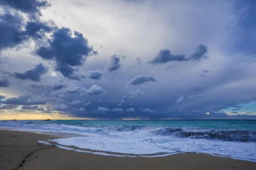 a beach with a cloudy sky and the ocean at Ble on Blue in Athanion
