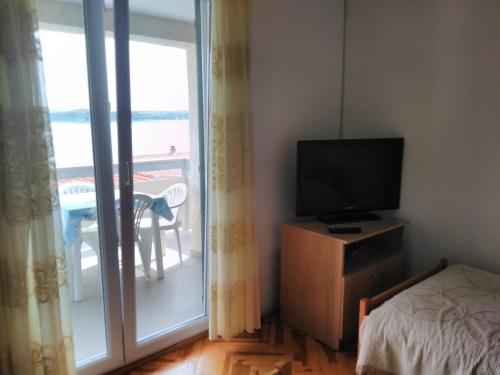 ein Schlafzimmer mit einem TV auf einer Kommode neben einem Fenster in der Unterkunft Apartment Davor - parking in Sali