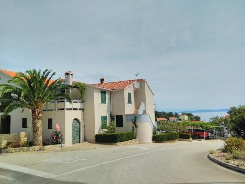 ein Haus mit einer Palme und einer Straße in der Unterkunft Apartment Davor - parking in Sali