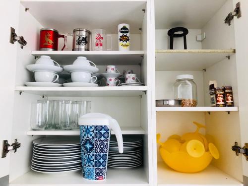 a pantry filled with dishes and cups and plates at Apartamento Frente Ao Mar in Guarujá