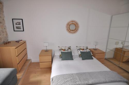 a bedroom with a bed with pillows and a mirror at Splendid one-bedroom apartment - Picasso 3 - StayInAntibes in Antibes
