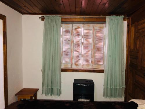 a bedroom with a window with green curtains at Lindo Departamentito en Creel in Creel