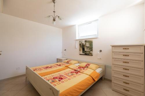 a bedroom with a bed and a dresser and a window at Appartamento del Cardellini in Santa Caterina