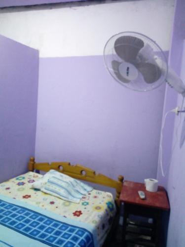 a bedroom with a bed and a table with a fan at Hospedaje Independencia Pucallpa in Pucallpa