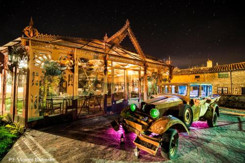 um carro velho estacionado em frente a um edifício em Posada del Indiano em Cidones