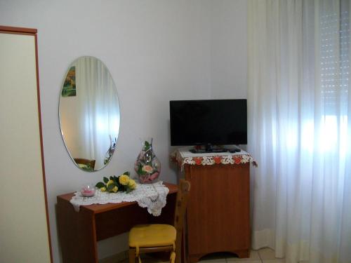 een woonkamer met een televisie en een spiegel bij Il Mulino in Furore