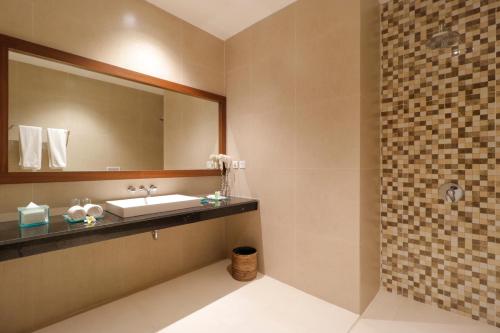 a bathroom with a sink and a mirror at Adi Dharma Hotel Legian in Legian