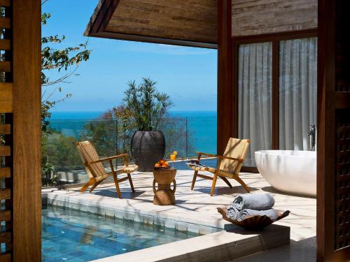 a bathroom with a tub and two chairs and a bath tub at Panacea Retreat in Bophut 