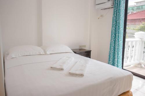a white bed with two towels on top of it at Island Inn in Boracay