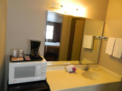 a bathroom with a sink and a microwave at Travelodge by Wyndham Evanston in Evanston