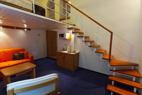 a staircase in a room with a couch and a table at Pension Ferdinand Panzio in Sfântu-Gheorghe