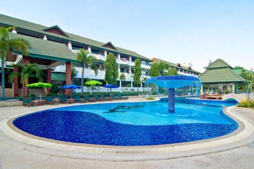 a large pool with an umbrella in front of a building at Grand Jomtien Palace Hotel - SHA Extra Plus in Jomtien Beach