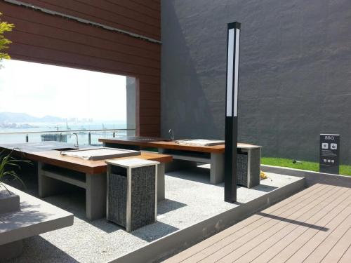 a table and benches on a patio with a view at Woodsbury Suites 7722 Butterworth Penang in Butterworth