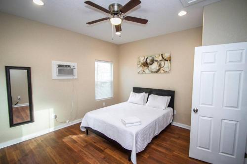 Schlafzimmer mit einem weißen Bett und einem Deckenventilator in der Unterkunft Douglas Way Remodeled House Near Downtown 1BA/1BA in San Antonio