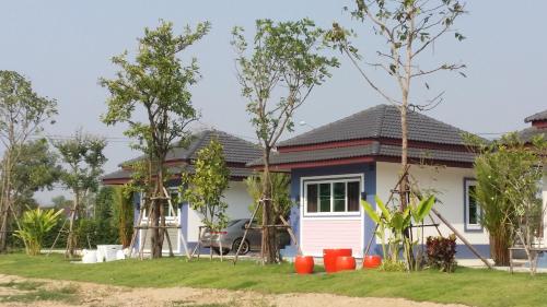 a house with a lot of trees in front of it at Araya Cottage in Ban Bung Thap Tae (1)