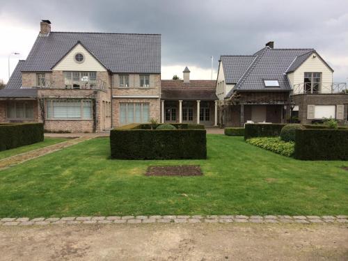 a large house with a large lawn in front of it at The Loft in Melsele