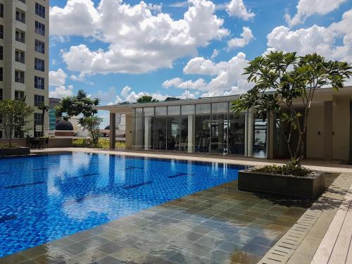 a large swimming pool in front of a building at Studio Apartment at M-Town Residence near Summarecon Mall Serpong By Travelio in Pumpangsineng