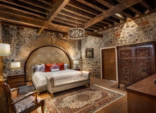 a bedroom with a bed in a room with stone walls at Hacienda Santo Cristo Hotel & Spa - Adults Only in Atlixco