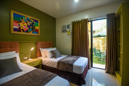 una camera d'albergo con due letti e una finestra di ETT HomeTel a Kalibo