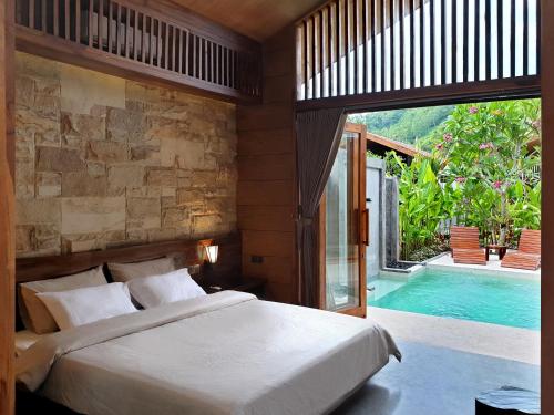 a bedroom with a bed and a swimming pool at Batatu Resort - Adults Only in Kuta Lombok