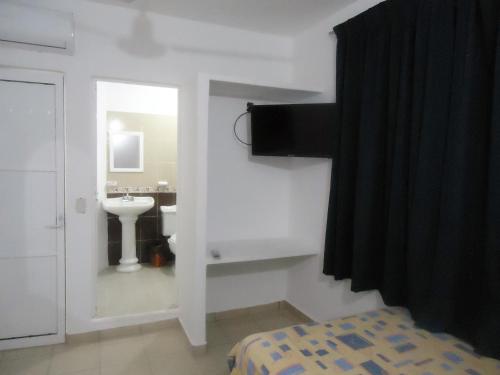 a white bathroom with a sink and a mirror at Hotel Olas Huatulco in Santa Cruz Huatulco