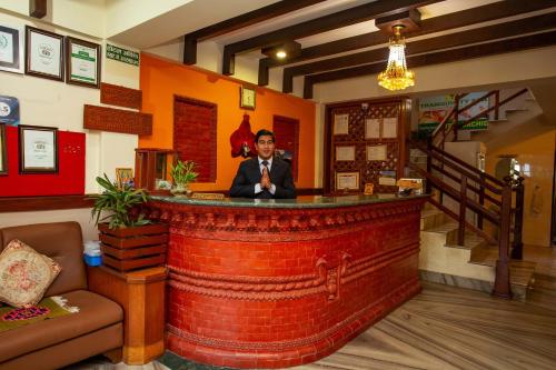 Un uomo seduto al bar in un ristorante di Hotel Orchid a Pokhara