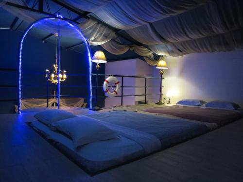 sypialnia z dużym łóżkiem z niebieskim oświetleniem w obiekcie 荷蘭洋行-寵物友善塩水燈會井仔腳塩田 w mieście Xuejia