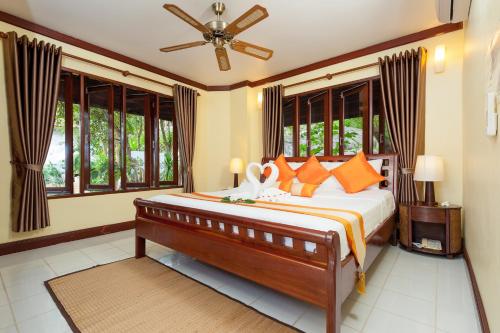 um quarto com uma cama grande com travesseiros laranja em Ban's Diving Resort em Ko Tao