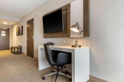 a room with a desk with a chair and a television at Cambria Hotel West Orange in West Orange