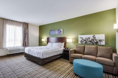a hotel room with a bed and a couch at Sleep Inn & Suites Yukon Oklahoma City in Yukon