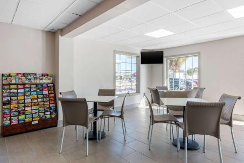 a dining room with tables and chairs and a tv at Econo Lodge Airport - RJ Stadium in Tampa