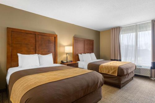 a hotel room with two beds and a window at Comfort Inn & Suites Peachtree Corners in Norcross