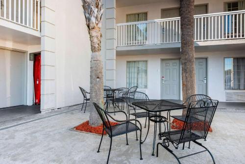 a group of tables and chairs in the courtyard of a building at Econo Lodge Airport - RJ Stadium in Tampa