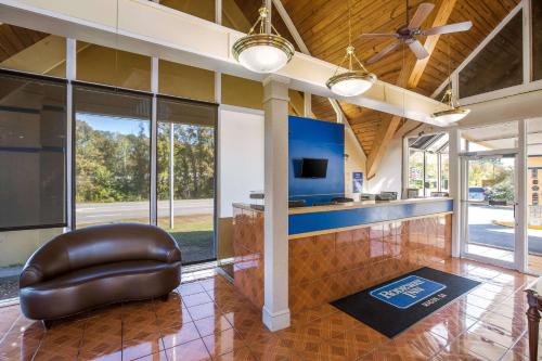 a living room with a ceiling fan and a chair at Super 8 by Wyndham Macon GA in Macon