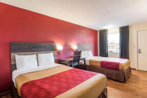 a hotel room with two beds and a desk at Econo Lodge Cloverdale in Cloverdale