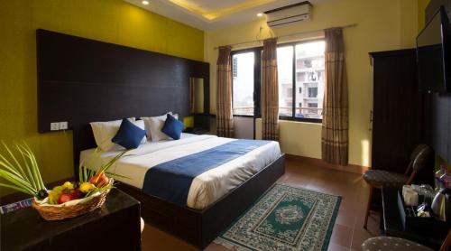 Pokój hotelowy z łóżkiem i koszem owoców na stole w obiekcie Golden Gate Hotel w mieście Pokhara