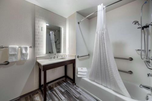 a bathroom with a sink and a tub and a shower at Comfort Inn & Suites Oklahoma City in Oklahoma City