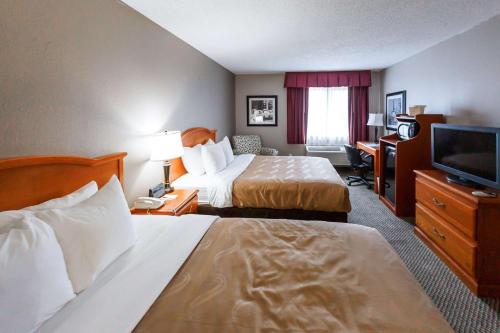 a hotel room with two beds and a flat screen tv at Quality Inn Burlington near Hwy 34 in Burlington