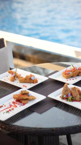 tre piatti di cibo su un tavolo vicino all'acqua di Kusuma Agrowisata Resort & Convention a Batu