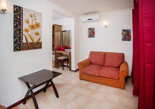 a living room with a red chair and a table at Talamba Blue in Blue Bay