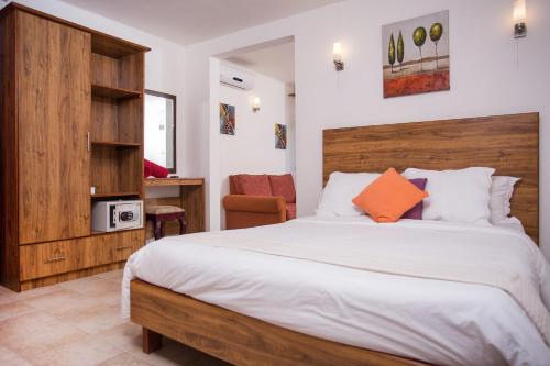 Schlafzimmer mit einem großen Bett mit einem Kopfteil aus Holz in der Unterkunft Talamba Blue in Blue Bay