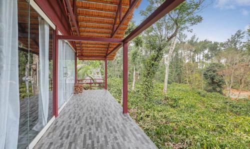 a porch of a house with a wooden roof at Itsy Hotels Jammabane Cottage in Madikeri