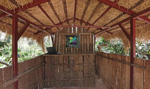 um quarto com um computador portátil numa parede de madeira em Itsy By Treebo - Jammabane Cottage With Mountain View em Madikeri