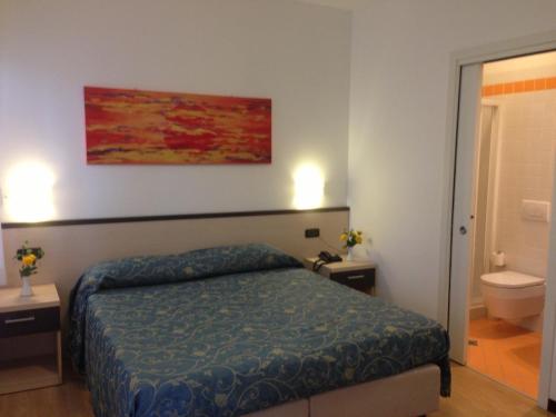 una camera con letto e un bagno con servizi igienici di Hotel Al Fogo a Bevazzana