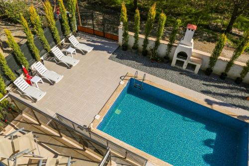 uma vista sobre uma piscina com cadeiras e árvores em Villa Central Dalyan em Muğla