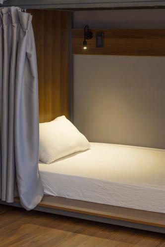 a bed in a room next to a window at Light House Hostel in Da Nang