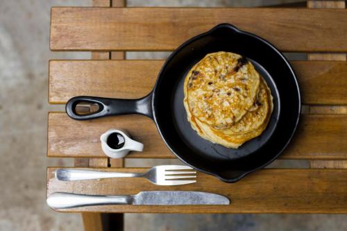a pancake in a pan on a wooden table at Light House Hostel in Da Nang