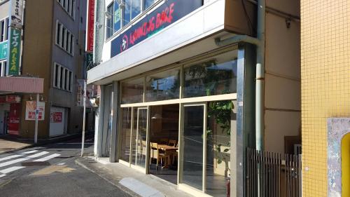 a store front with glass doors on a city street at Running Bare in Fuji