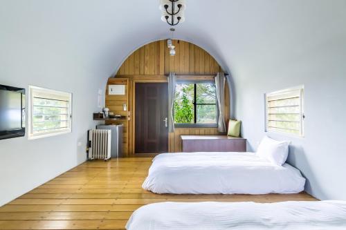 Duas camas num quarto com uma janela em Ville Greensward em Taitung City